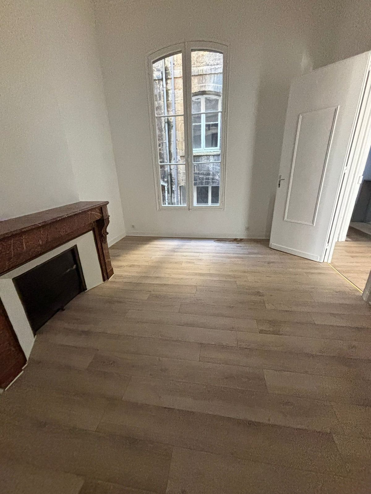 Pièce rénovée avec parquet, cheminée et baie vitrée à Bordeaux — rénovation EVO EPC